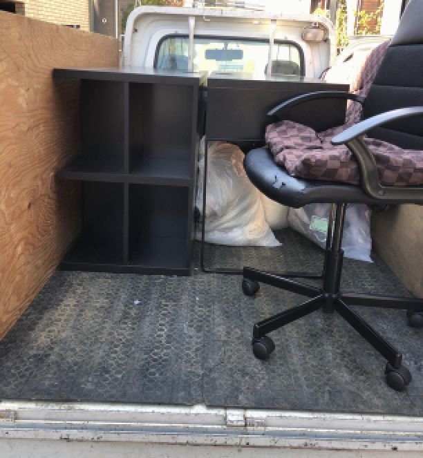 トラック荷台に置かれた椅子、机、ゴミ袋